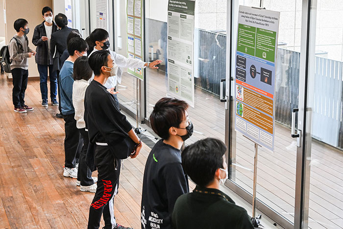 数名与会者在观看有关全球公民教育的学术海报。